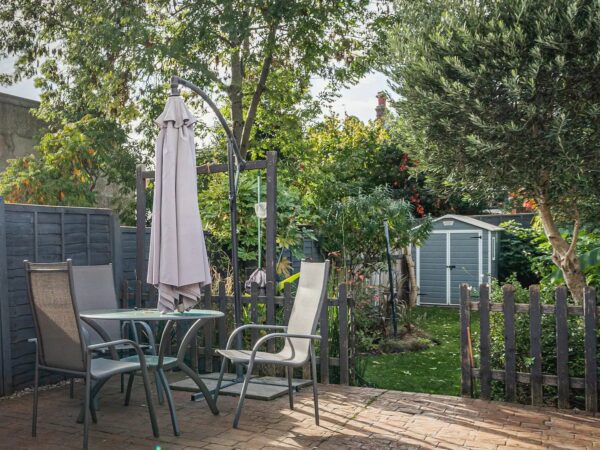 Outdoor dining space with table, chairs, and umbrella at Trade Stays contractor accommodation