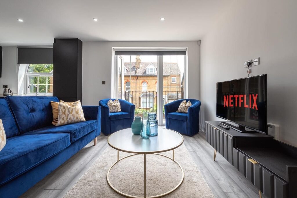 Modern serviced apartment living room in Staines with sofas, TV, and natural light – Trade Stays accommodation